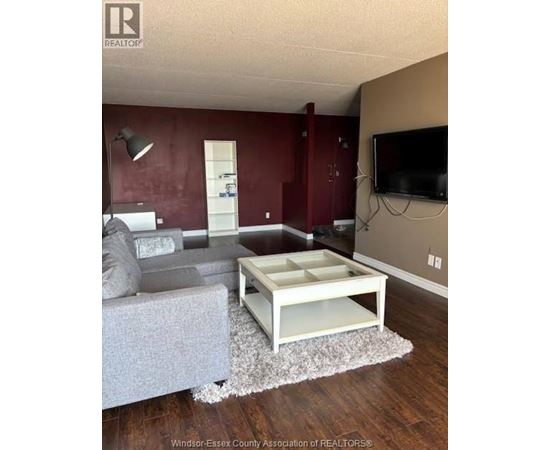 A living room with a grey couch and a white coffee table.