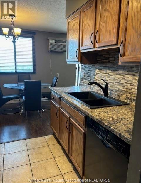 A kitchen with wooden cabinets and a granite countertop.