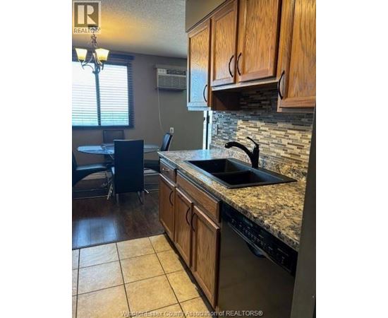 A kitchen with wooden cabinets and a granite countertop.