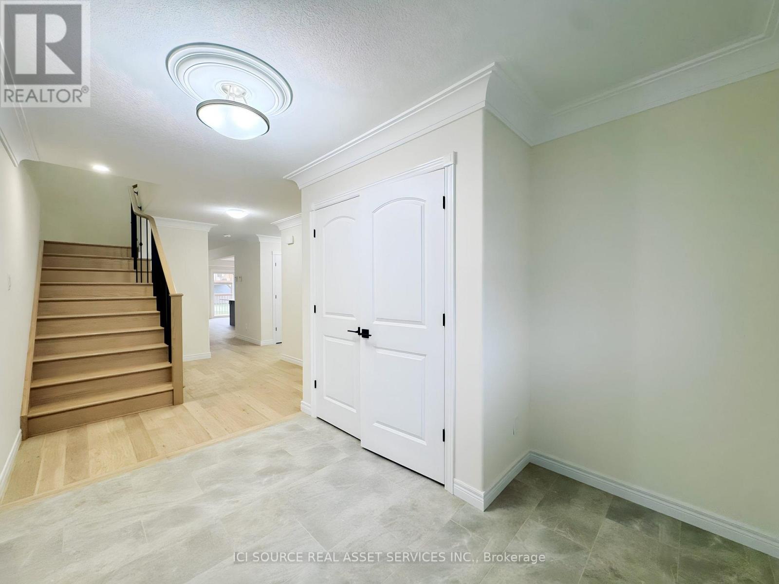 A white door is in a room with a staircase.