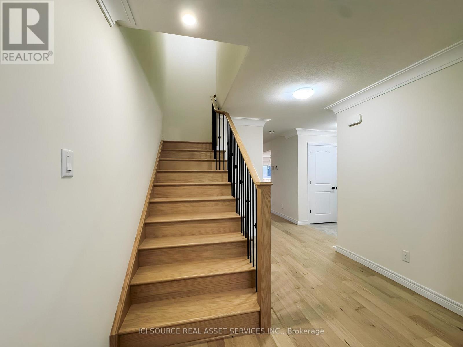 A staircase with wooden steps and a white wall on the side.