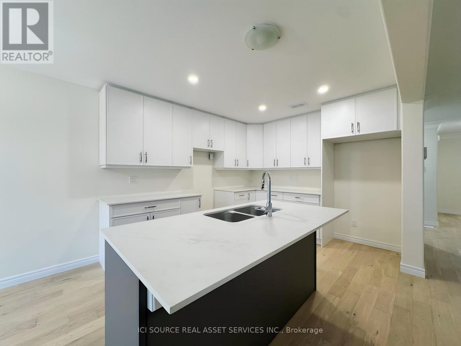 A modern kitchen with white cabinets and a central island.