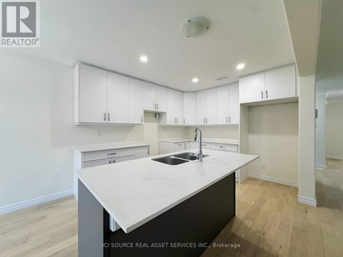 A modern kitchen with white cabinets and a central island.