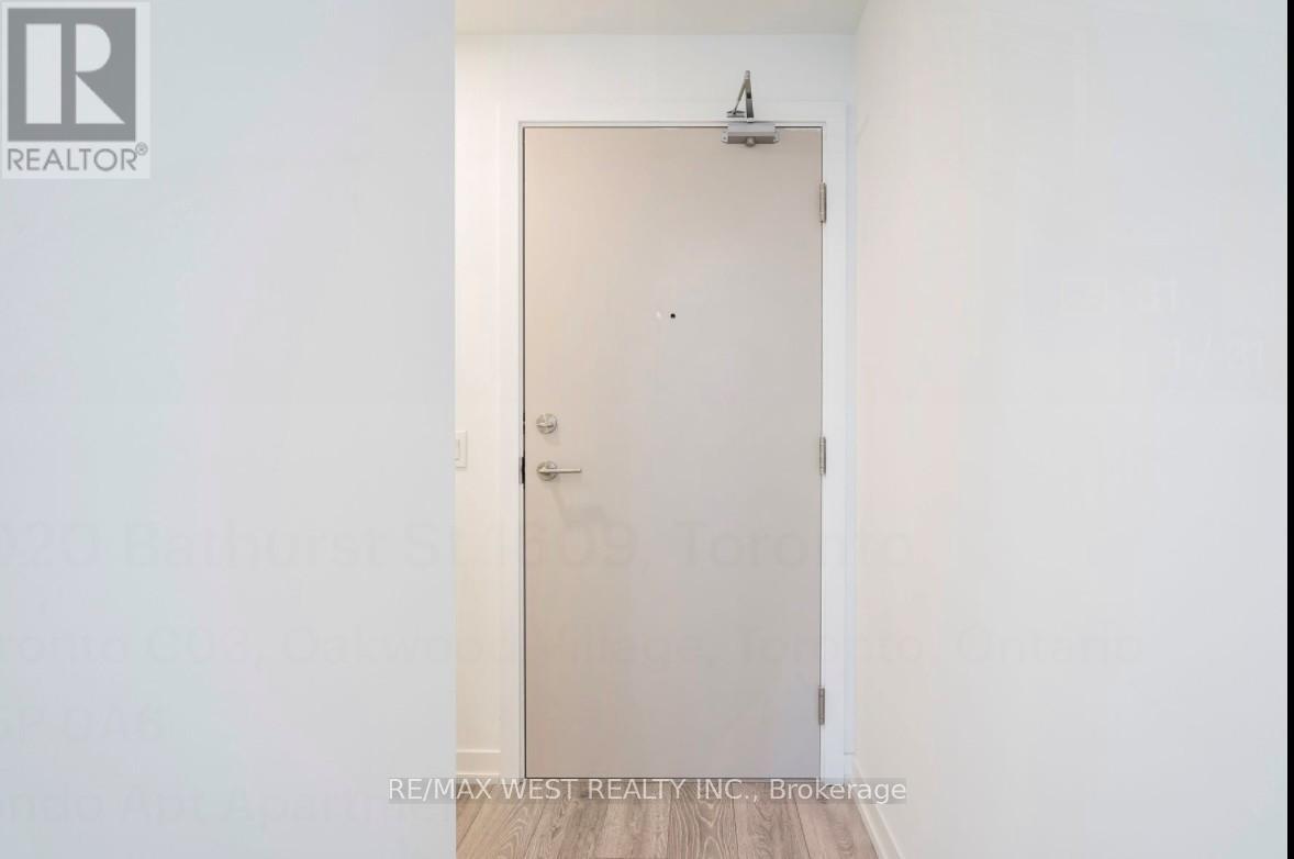 A white door in a room with a brokerage sign on the wall.
