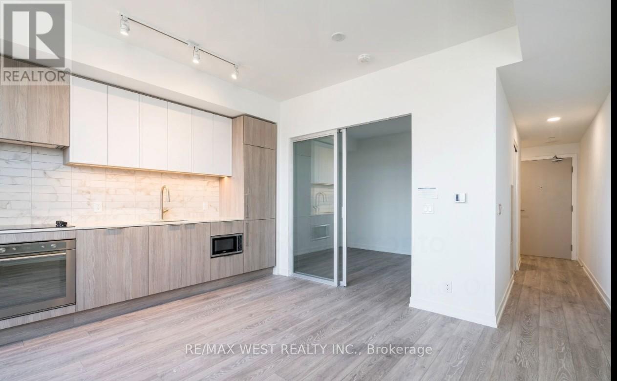 A modern kitchen with wooden cabinets and a glass door.