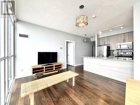 A modern living room with a wooden floor and a television on a wooden stand.