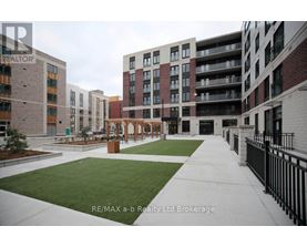 A view of a courtyard with a fence and a building in the background.