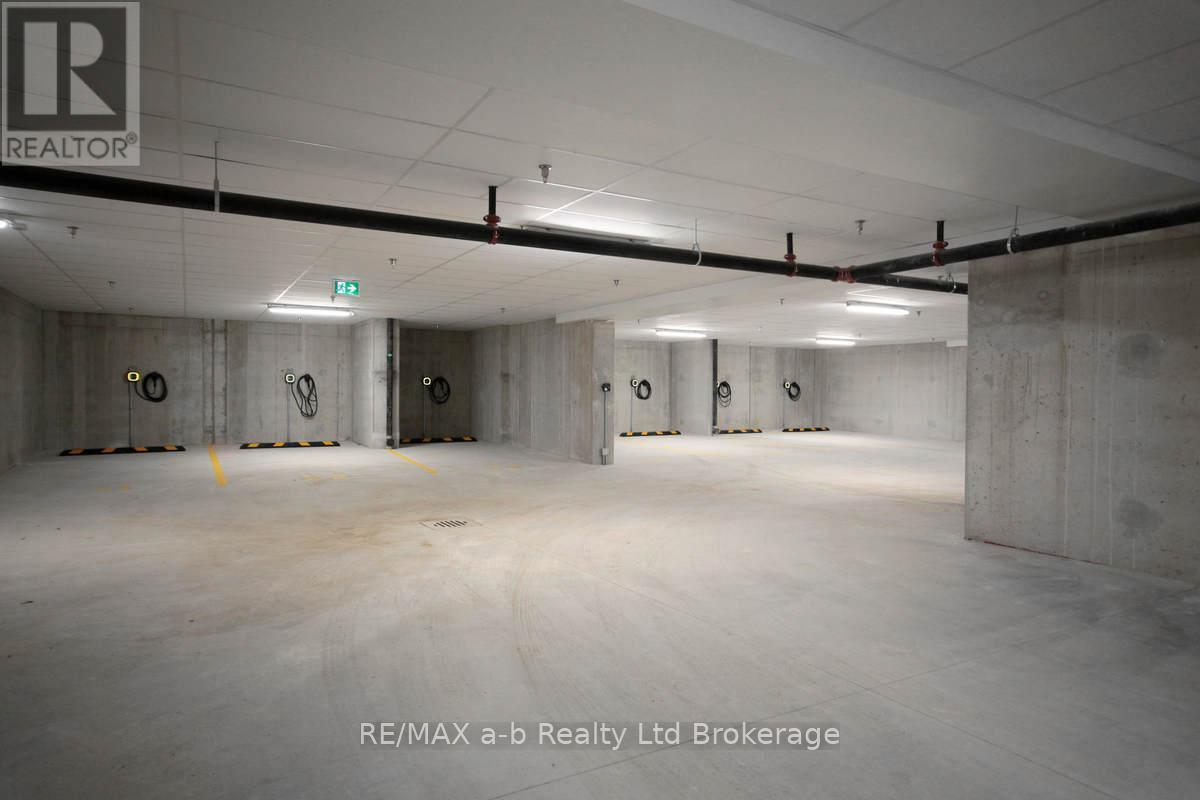 A large, empty warehouse space with concrete walls and floors, and a logo that reads "RE/MAX a-b Realty Ltd Brokerage" in the bottom right corner.