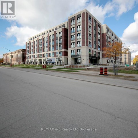 A large multi-story building with a parking lot in front.