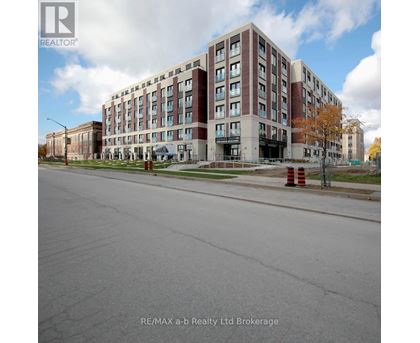 A large multi-story building with a parking lot in front.