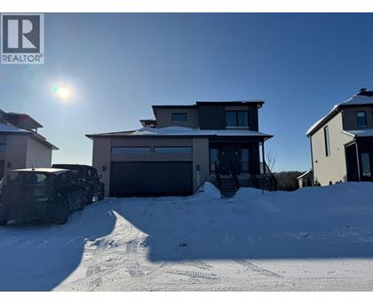 A house with a car parked in front of it in the snow.