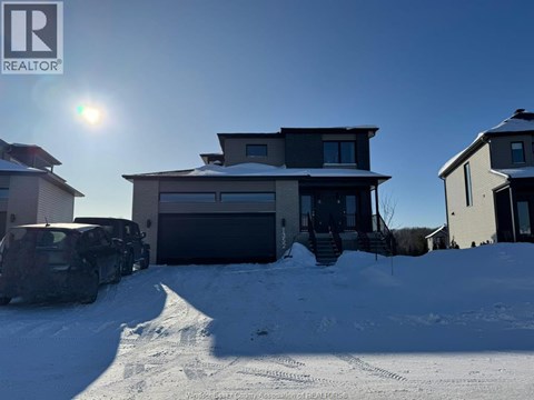 A house with a car parked in front of it in the snow.