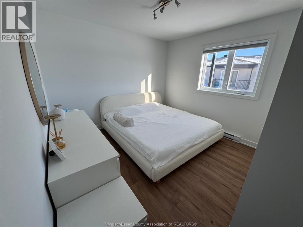 A bedroom with a bed, dresser, and window.