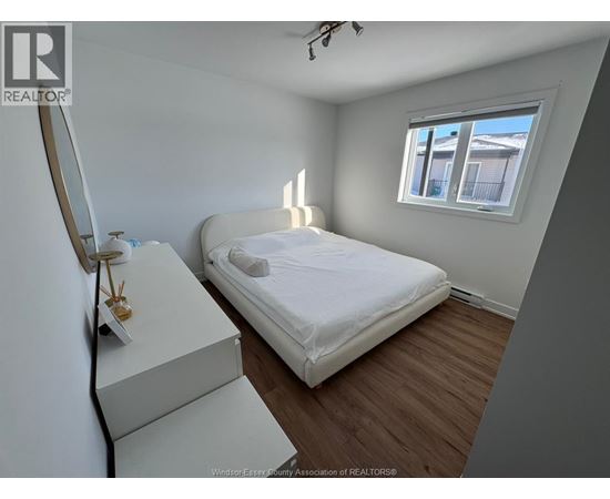 A bedroom with a bed, dresser, and window.