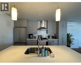 A kitchen with a sink and a stove top oven.