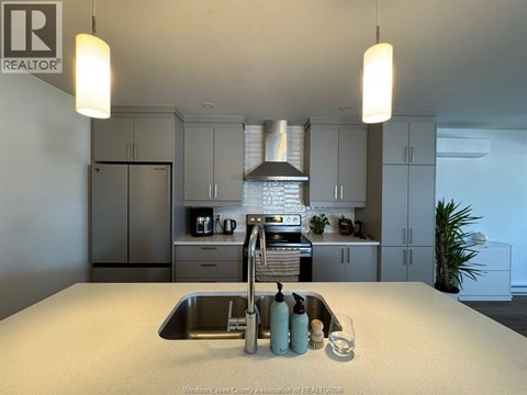A kitchen with a sink and a stove top oven.
