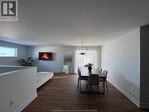 A dining room with a wooden table and chairs.