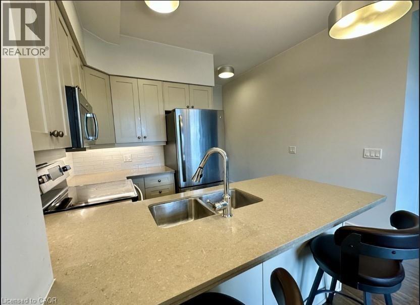 A kitchen with a sink and a refrigerator.