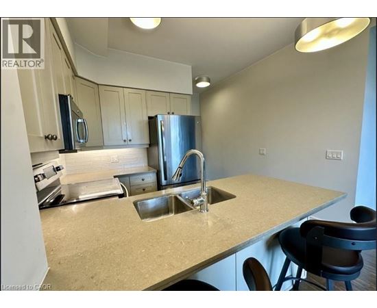 A kitchen with a sink and a refrigerator.