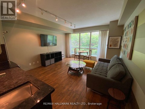 A living room with a brown couch and a glass coffee table.