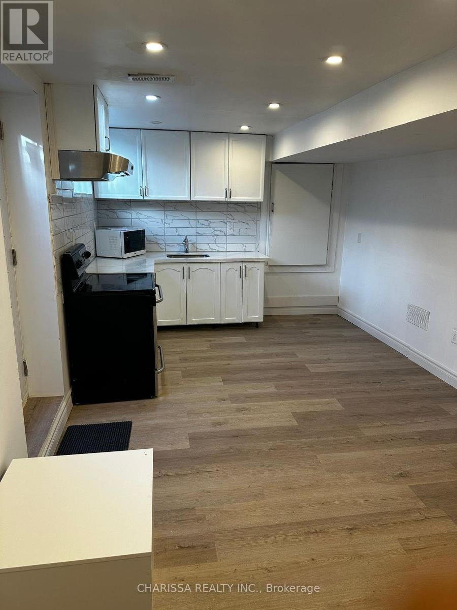 A kitchen with white cabinets and a marble backsplash.