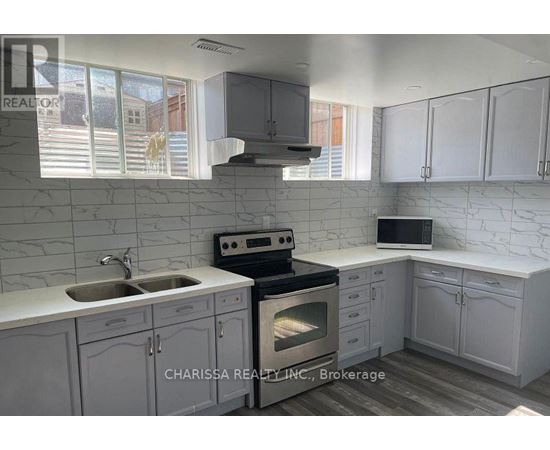A kitchen with white cabinets and a marble backsplash.