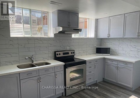 A kitchen with white cabinets and a marble backsplash.