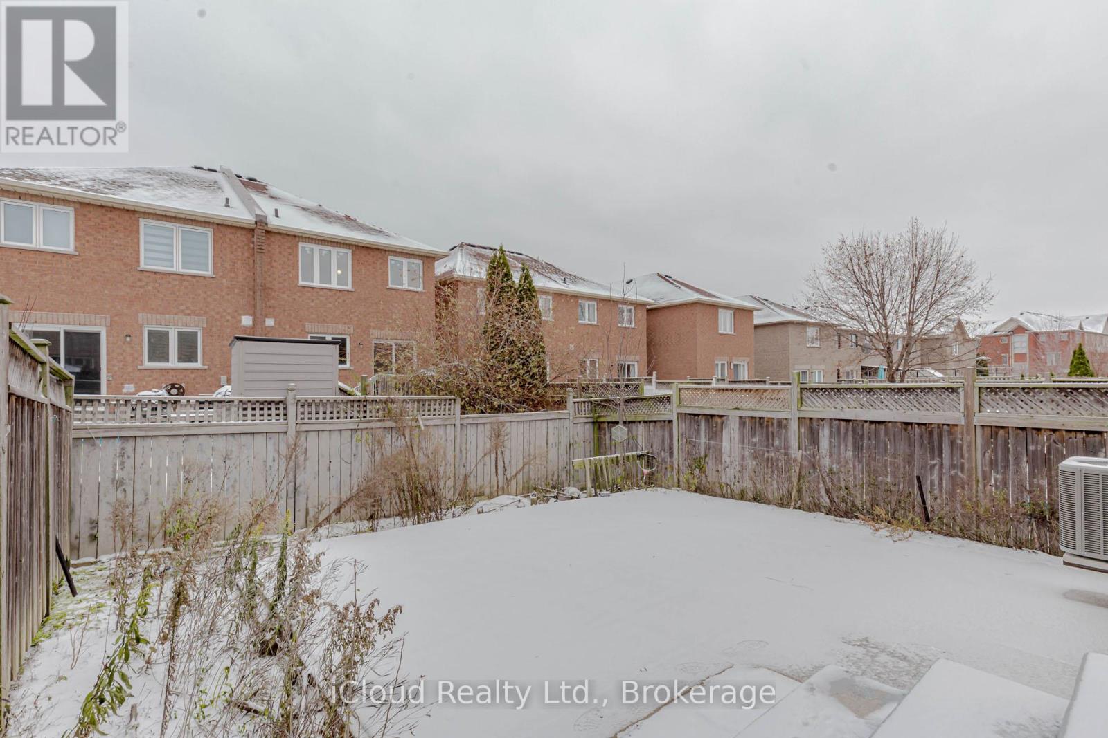 A snow-covered yard in front of a brick apartment building.