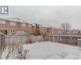 A snow-covered yard in front of a brick apartment building.