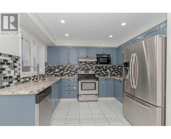 A kitchen with a stainless steel refrigerator and a checkered backsplash.