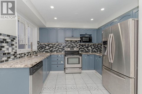 A kitchen with a stainless steel refrigerator and a checkered backsplash.