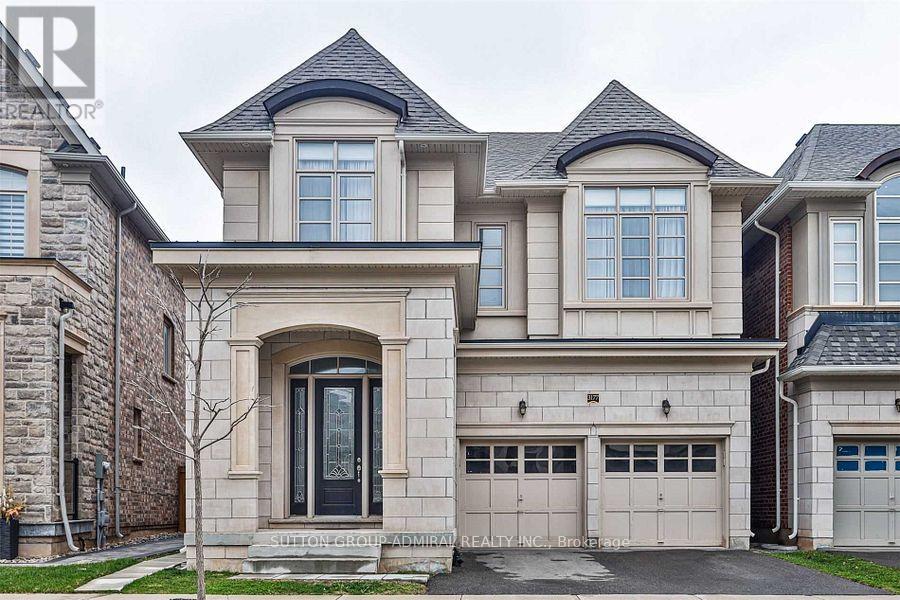 A large, two-story house with a stone facade and a black door.