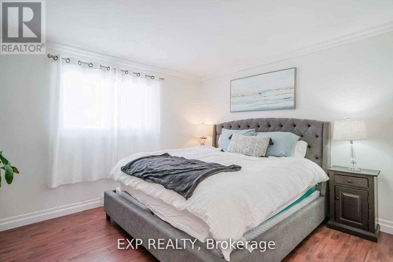A bedroom with a large bed and a nightstand with a lamp.