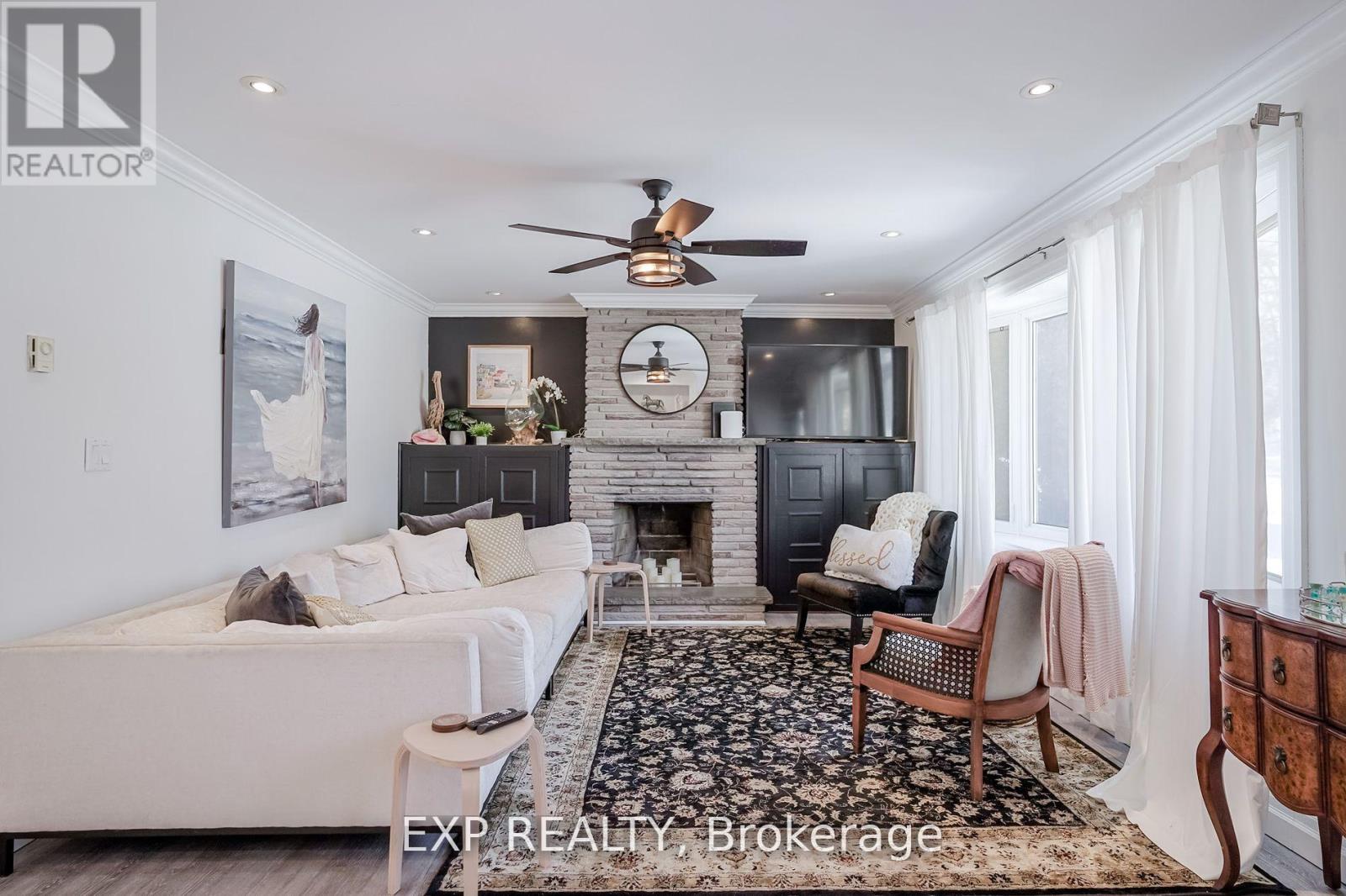 A living room with a fireplace, a couch, a chair, and a rug.