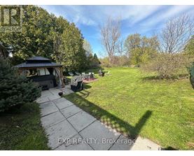 A backyard with a gazebo and a concrete walkway.