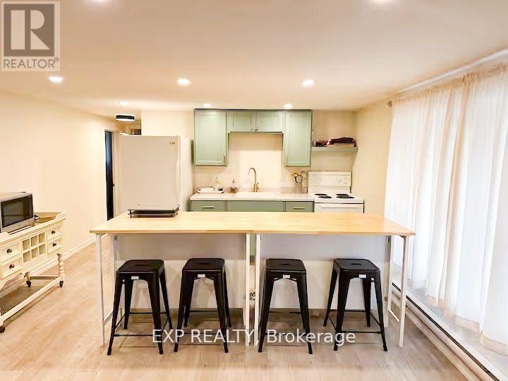 A kitchen with a table and stools in the middle of the room.