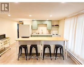 A kitchen with a table and stools in the middle of the room.