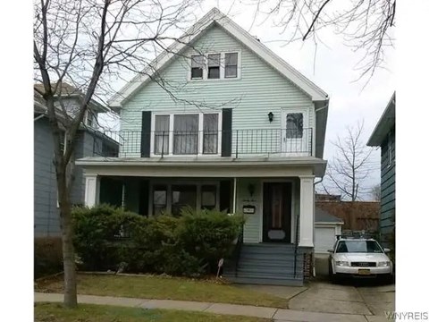 A two-story house with a white car parked in front.