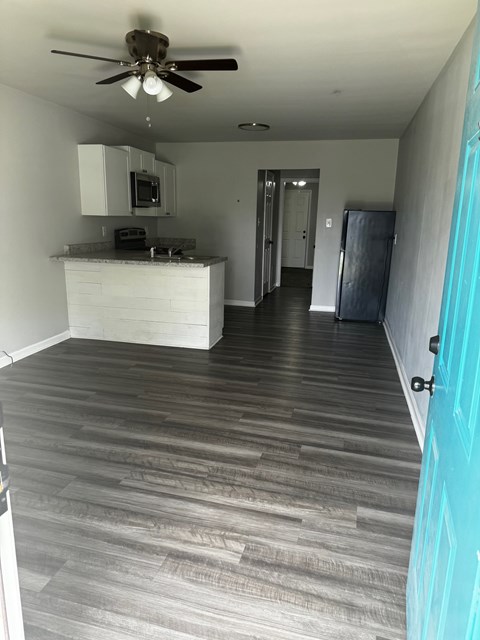 A kitchen with a white counter and a ceiling fan.