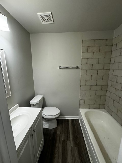 A white toilet sits next to a white sink in a small bathroom.