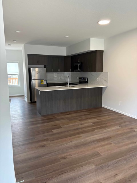 A kitchen with a wooden floor and a counter.