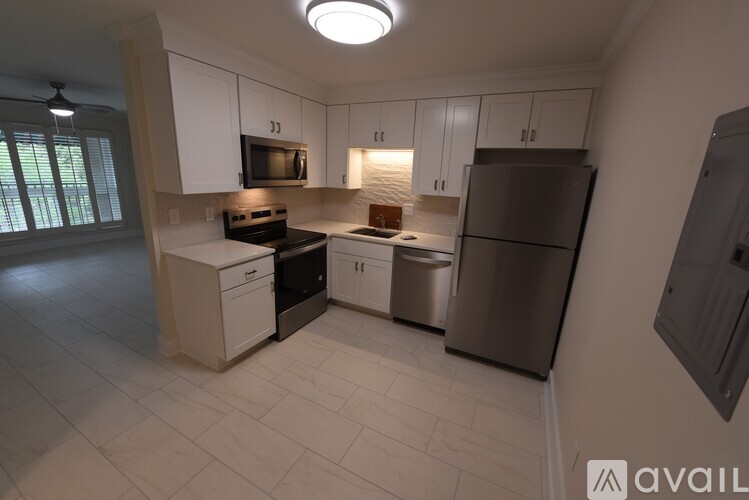 A kitchen with white cabinets and a microwave above the stove.