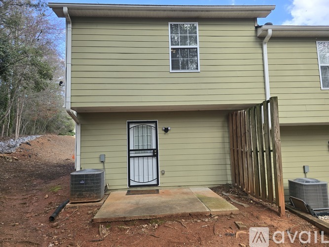 A house with a black door and a window is for sale.