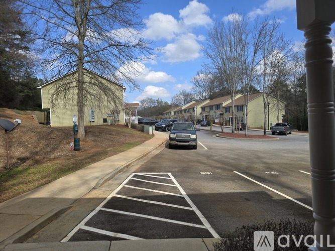A street view with cars parked on the side and a church in the background.