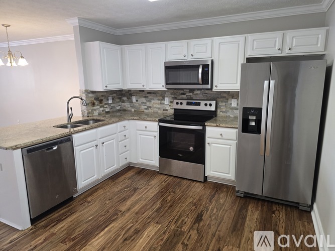 A kitchen with white cabinets and stainless steel appliances.
