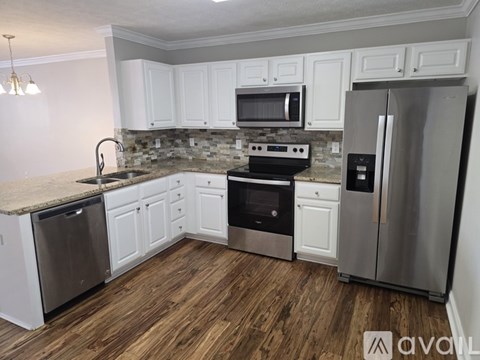 A kitchen with white cabinets and stainless steel appliances.