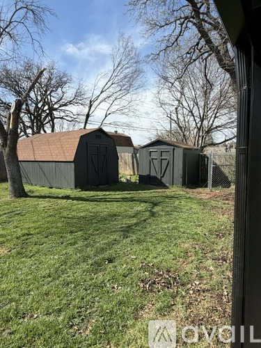 A grassy field with a shed and a fence.