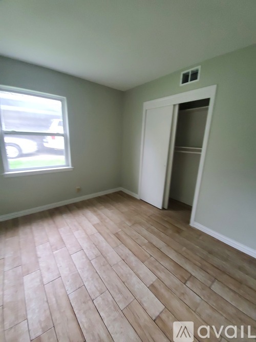 A room with a wooden floor and a white door.