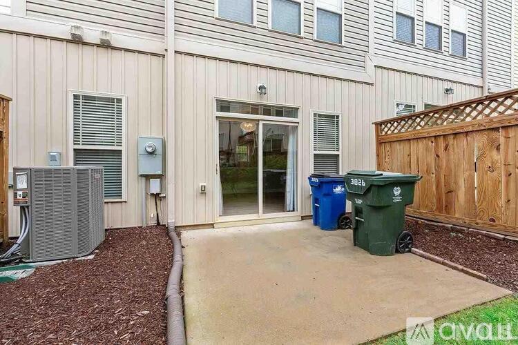 A building with a blue and green trash can in front of it.