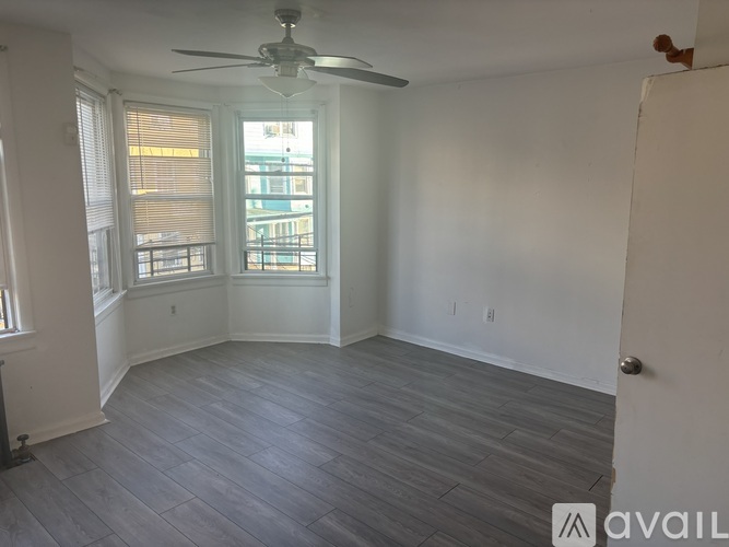 A room with a ceiling fan and a window with blinds.